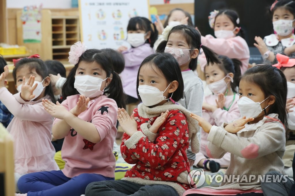 Children wearing masks participate in an activity at a day care center in Gwangju, 330 kilometers south of Seoul, on March 10, 2021. (Yonhap)