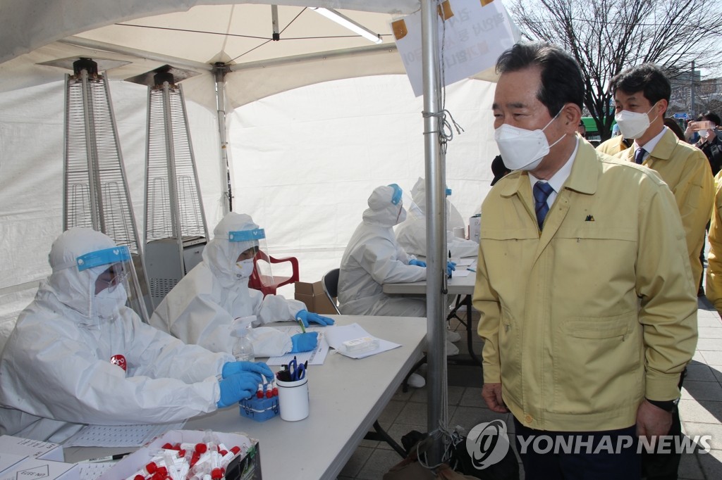 Prime Minister Chung Sye-kyun (R) inspects an outdoor COVID-19 testing station set up in front of Guro Station in western Seoul, which is populated with migrant workers, on March 22, 2021, amid the spread of the virus. (Yonhap)