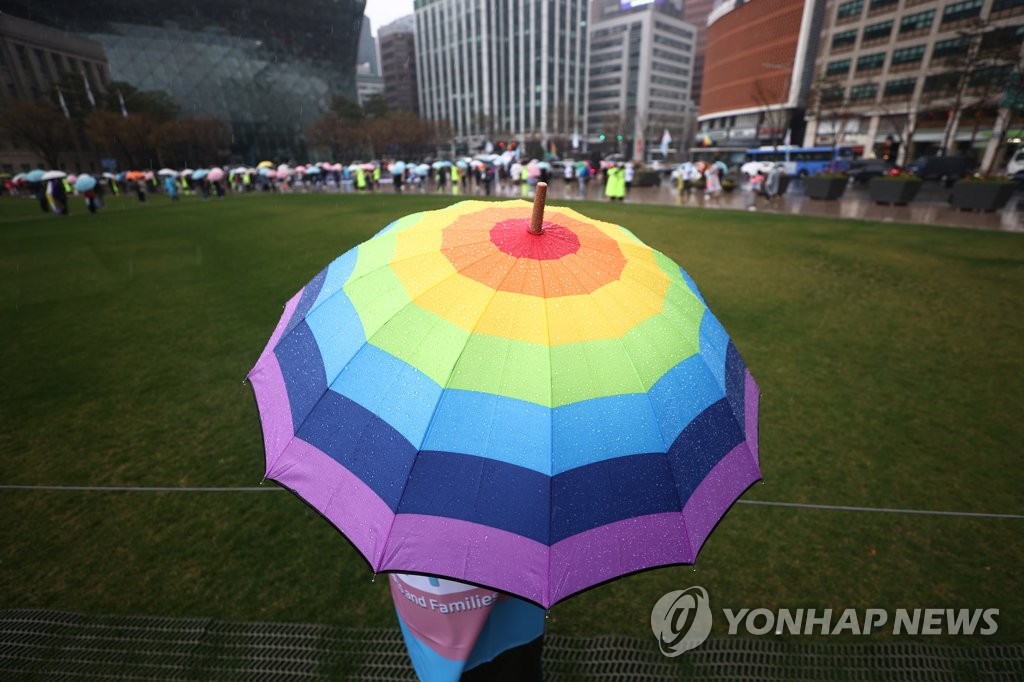 In this file photo, a participant holds an umbrella with colors symbolic of the transgender community as activists hold a news conference in a central square in Seoul on March 27, 2021, on the occasion of March 31 International Transgender Day of Visibility. (Yonhap)