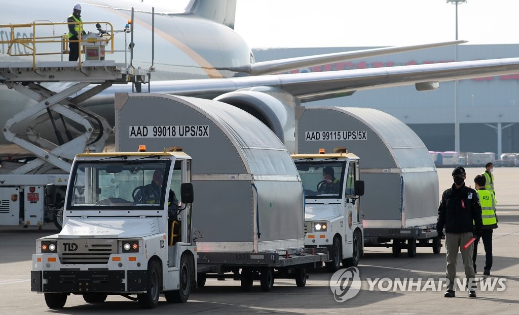 到着したワクチンを関係者が貨物機から下ろしている＝３１日、仁川（聯合ニュース）