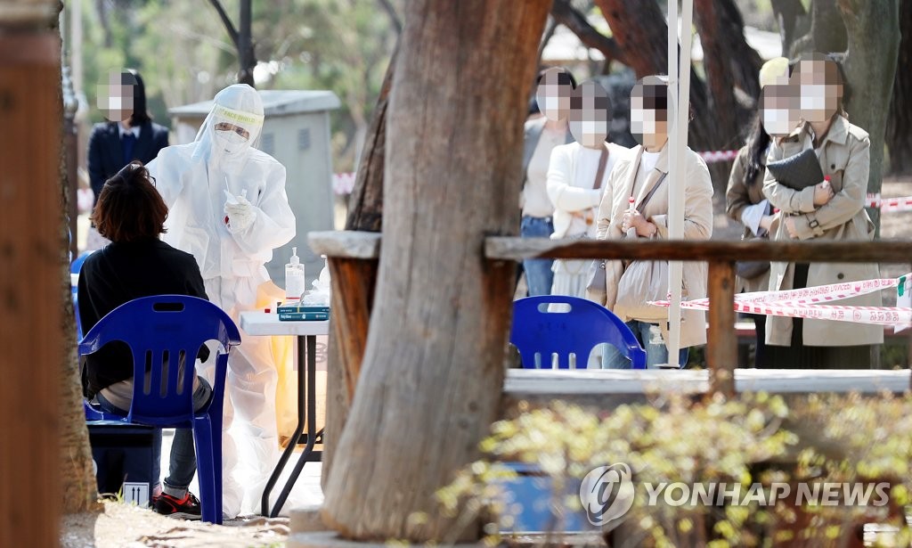 Des gens se font dépister pour le nouveau coronavirus le mardi 6 avril 2021 dans un parc à Incheon après l'apparition d'un cluster d'infections dans le quartier. 