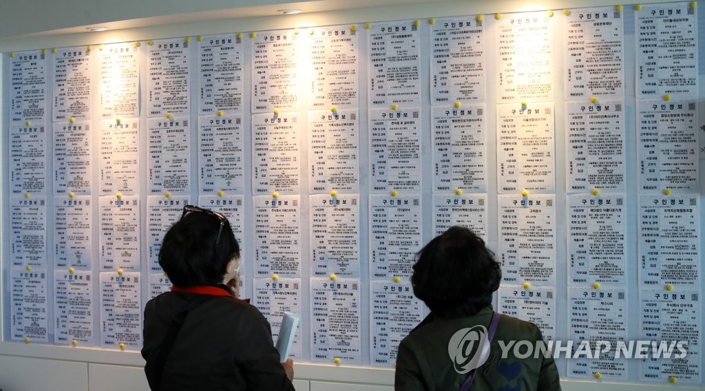 Des demandeuses d'emploi consultent un tableau d'affichage dans un centre de placement à Séoul, le 14 avril 2021.