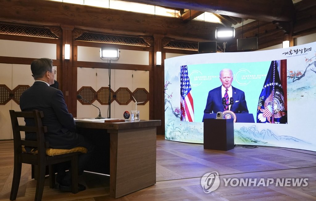South Korean President Moon Jae-in listens to U.S. President Joe Biden during the virtual Leaders Summit on Climate hosted by the latter on Earth Day at the presidential office in Seoul on April 22, 2021. The leaders are set to hold their first in-person summit in Washington in late May. (Yonhap)