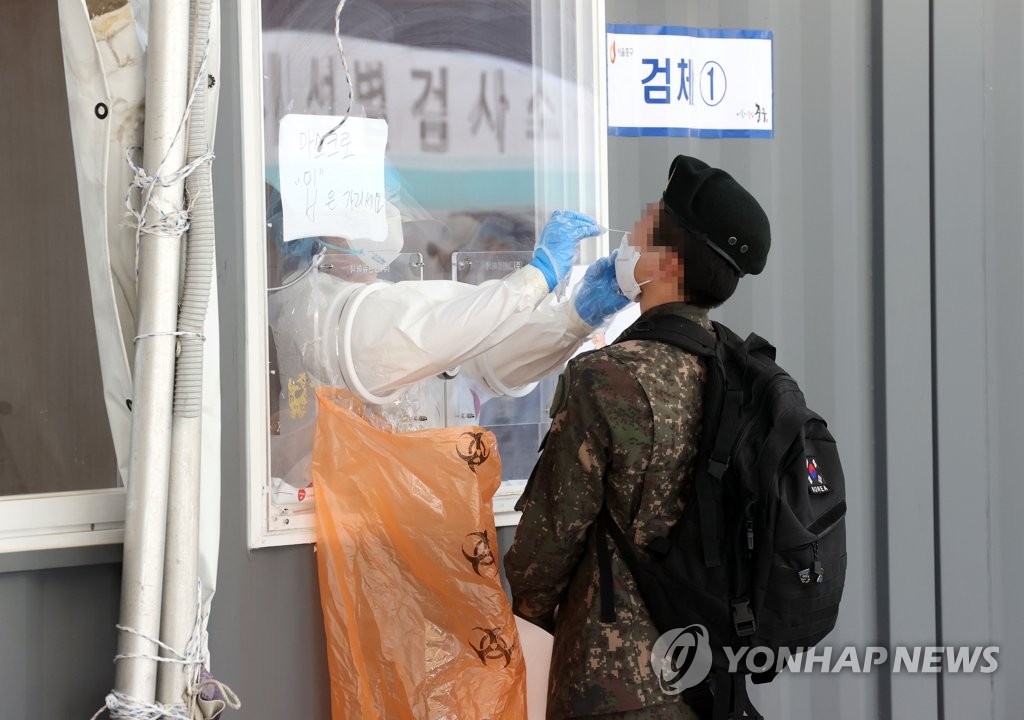 In this file photo, taken May 24, 2021, a service member undergoes a COVID-19 test at a makeshift testing station in front of Seoul Station in central Seoul. (Yonhap) 