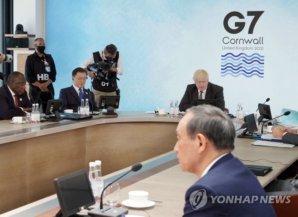 Le président Moon Jae-in (2e en partant de la gauche) assiste à une séance plénière du sommet du Groupe des Sept (G7), en compagnie d'autres dirigeants, dont le Premier ministre japonais Yoshihide Suga (à droite), au Carbis Bay Hotel & Estate en Cornouailles, en Grande-Bretagne, le 13 juin 2021.