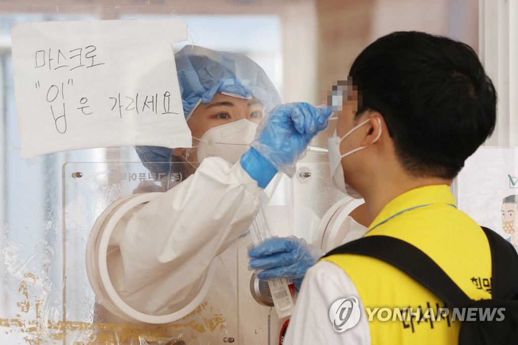 A medical worker carries out COVID-19 tests at a makeshift clinic in central Seoul on June 20, 2021. (Yonhap)