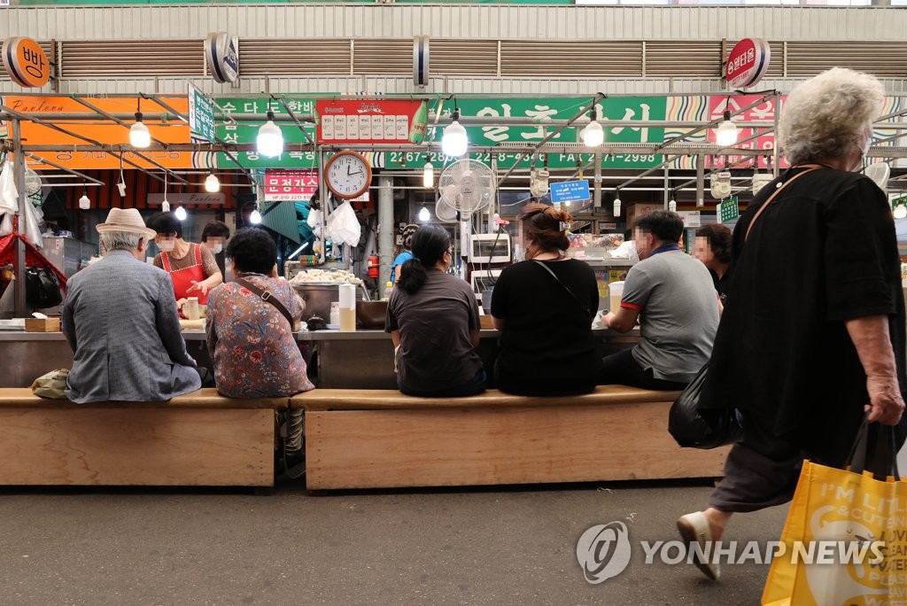 ソウル・清渓川沿いの広蔵市場で食事をする市民。私的な集まりの人数制限は７月から緩和される＝２８日、ソウル（聯合ニュース）