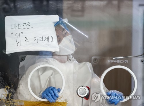 A medical worker is in preparation for a COVID-19 test in Seoul on July 4, 2021. (Yonhap) 