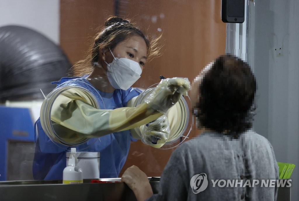 A medical worker carries out a COVID-19 test at a makeshift clinic in Seoul on July 12, 2021. (Yonhap)
