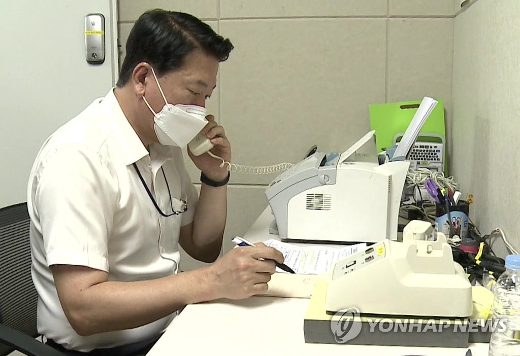 This photo provided by the unification ministry on July 27, 2021, shows a government official speaking with a North Korean counterpart over a direct hotline phone at an inter-Korean communication office in the North's border town of Kaesong. (PHOTO NOT FOR SALE) (Yonhap)