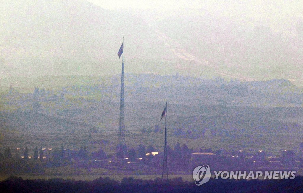 韓国の京畿道・坡州の南北軍事境界線近くから眺めた非武装地帯（ＤＭＺ）の様子。韓国と北朝鮮の国旗が掲げられている＝２７日、坡州（聯合ニュース）