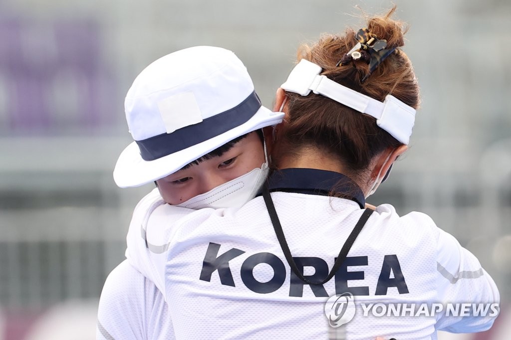An San of South Korea (L) embraces her coach Ryu Su-jeong after winning the gold medal in the women's individual archery event at the Tokyo Olympics at Yumenoshima Park Archery Field in Tokyo on July 30, 2021. (Yonhap)