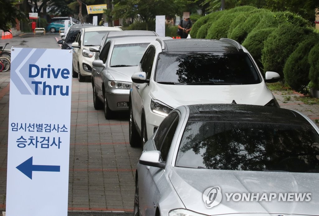 Vehicles line up at a drive-through COVID-19 screening center in northern Seoul on Aug. 2, 2021. (Yonhap)