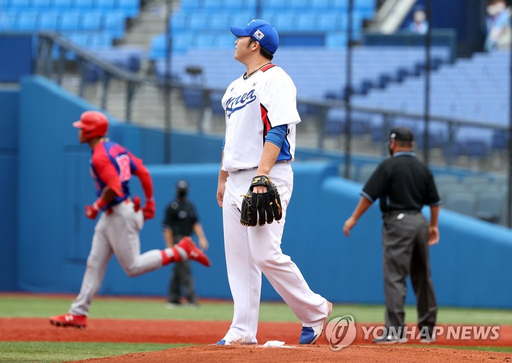 Kim Min-woo of South Korea (R) reacts to a two-run home run by Julio Rodriguez of the Dominican Republic during the top of the first inning of the bronze medal game at the Tokyo Olympic baseball tournament at Yokohama Stadium in Yokohama, Japan, on Aug. 7, 2021. (Yonhap)
