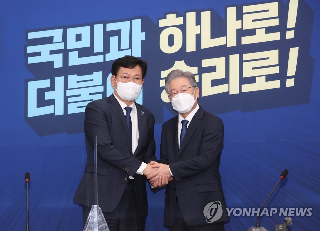Democratic Party Chairman Song Young-gil (L) and the party's presidential nominee, Lee Jae-myung, pose for photos at a meeting at the National Assembly in Seoul on Oct. 11, 2021. (Pool photo) (Yonhap)