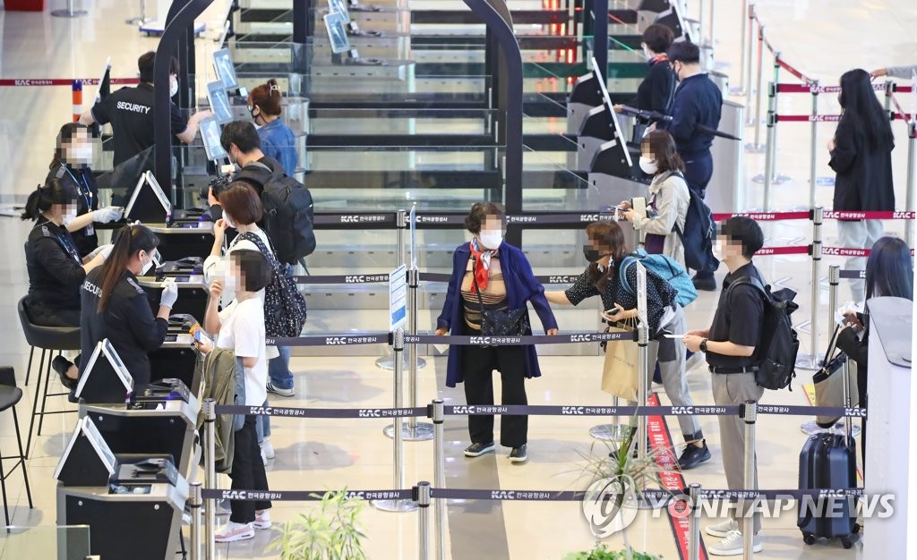 金浦空港の国内線で搭乗手続きをする人たち＝１５日、ソウル（聯合ニュース）