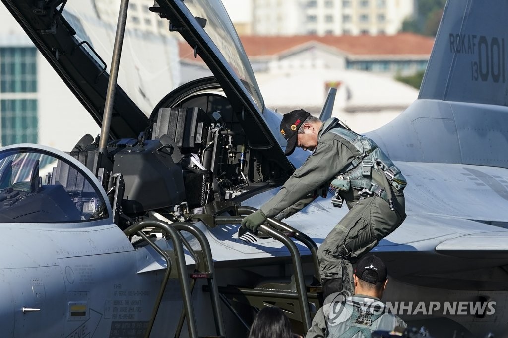 El presidente surcoreano, Moon Jae-in, vestido con uniforme de piloto, baja de un caza FA-50 autóctono, el 20 de octubre de 2021, en la Base Aérea de Seúl, en Seongnam, al sur de la capital, para asistir a la ceremonia de apertura de la Exhibición Internacional del Aeroespacio y la Defensa de Seúl, una exhibición de defensa bienal que ofrece una mirada profunda al armamento militar de última generación.