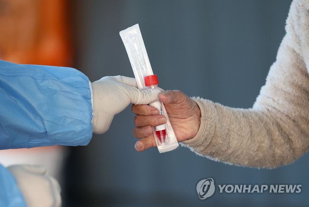 Une personne reçoit un kit de dépistage du nouveau coronavirus (Covid-19) au centre installé devant la gare de Séoul, le lundi 25 octobre 2021. Les autorités ont rapporté ce jour 1.190 nouvelles infections.