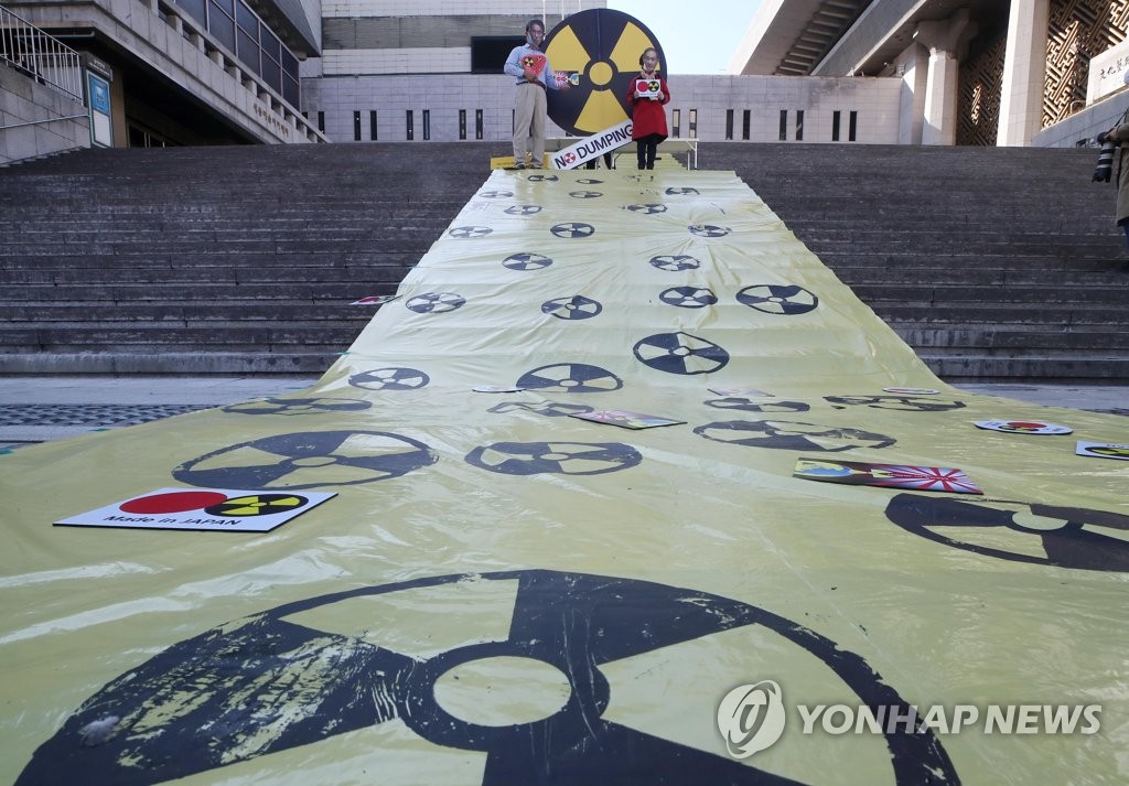 Los activistas surcoreanos celebran una manifestación en Seúl, el 25 de octubre de 2021, llevando máscaras que representan a los primeros ministros japoneses en ejercicio y anteriores, para condenar el plan de Japón de verter agua radiactiva al mar desde su paralizada planta de energía nuclear de Fukushima.