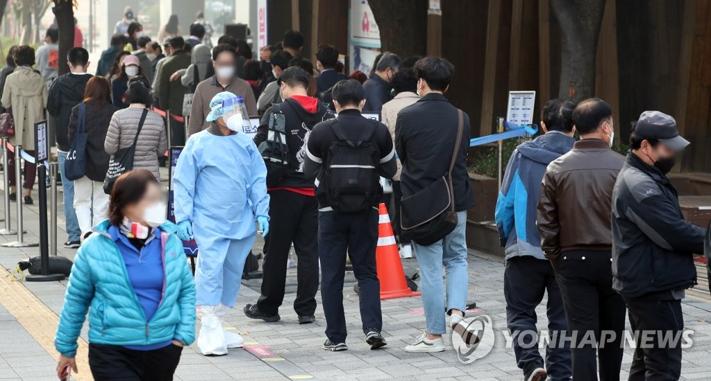 A COVID-19 testing station in Seoul's eastern district of Songpa is crowded with people lined up for diagnostic tests on Oct. 27, 2021, as South Korea reported a jump in the daily caseload to nearly 2,000, ahead of the start of a new scheme aimed at a gradual lifting of virus curbs. (Yonhap)