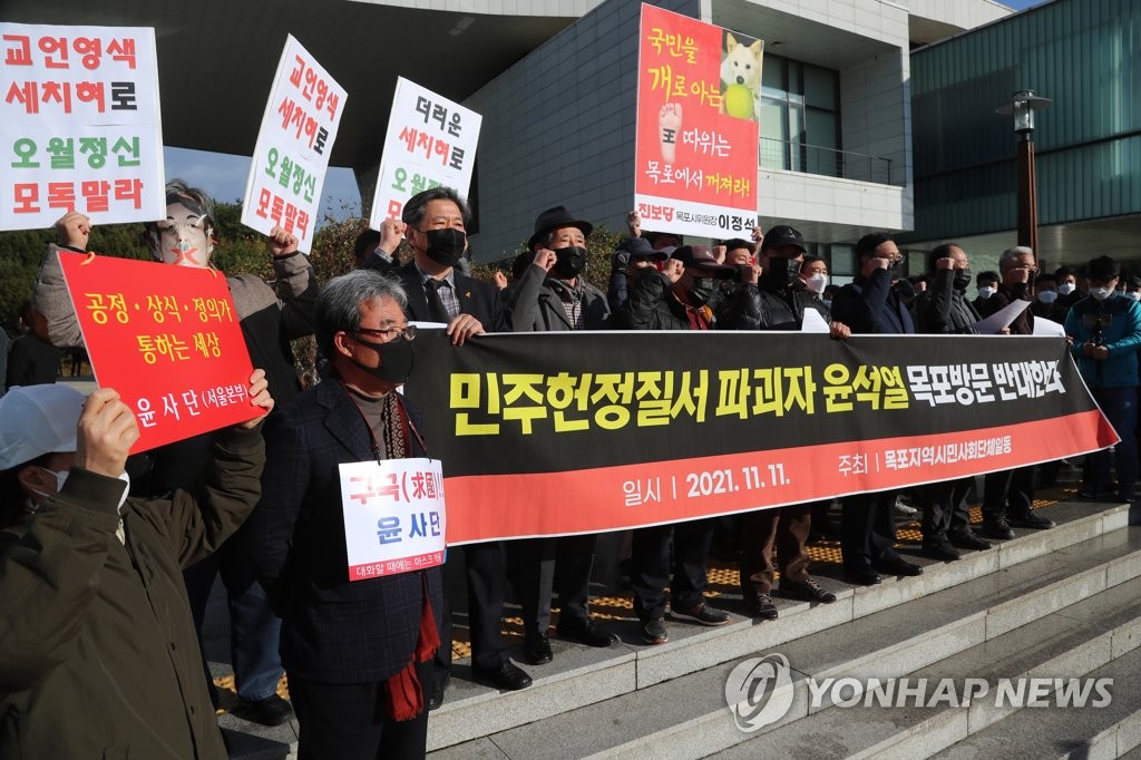 Activists supporting and opposing Yoon Seok-youl, the presidential nominee of the People Power Party, chant slogans outside the Kim Dae Jung Nobel Peace Prize Memorial in the southwestern city of Mokpo on Nov. 11, 2021. (Yonhap)
