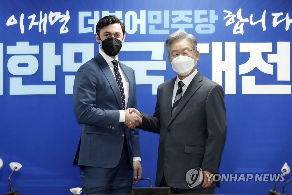 Lee Jae-myung (dcha.), el candidato presidencial del gobernante Partido Democrático (DP, según sus siglas en inglés), le da la mano al senador estadounidense Jon Ossoff, el 12 de noviembre de 2021, en la sede del DP, en Seúl. (Foto del cuerpo de prensa. Prohibida su reventa y archivo)
