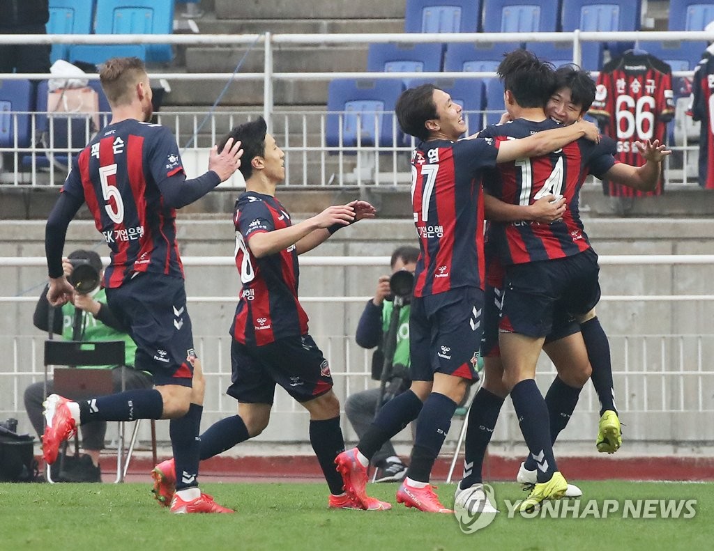 Suwon FC players celebrate a goal by Jeong Jae-yong (R) during their 3-2 victory over Jeonbuk Hyundai Motors in the K League 1 match at Suwon World Cup Stadium in Suwon, some 45 kilometers south of Seoul, on Nov. 21, 2021. (Yonhap)