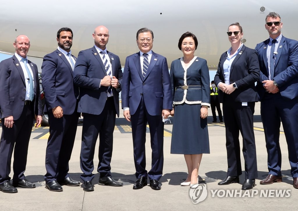 Le président Moon Jae-in (au c.) et son épouse, Kim Jung-sook, posent avec des agents de sécurité australiens à l'aéroport de Kingsford-Smith à Sydney, le 15 décembre 2021, avant leur départ pour Séoul après une visite d'Etat de quatre jours en Australie.