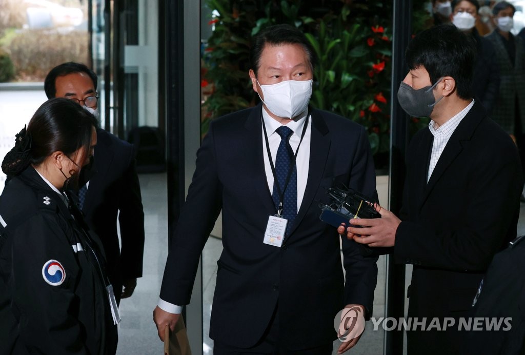 SK Group Chairman Chey Tae-won (C) enters the government complex building in the administrative city of Sejong on Dec. 15, 2021, to attend a session by the Fair Trade Commission over an unfair business case. (Yonhap)