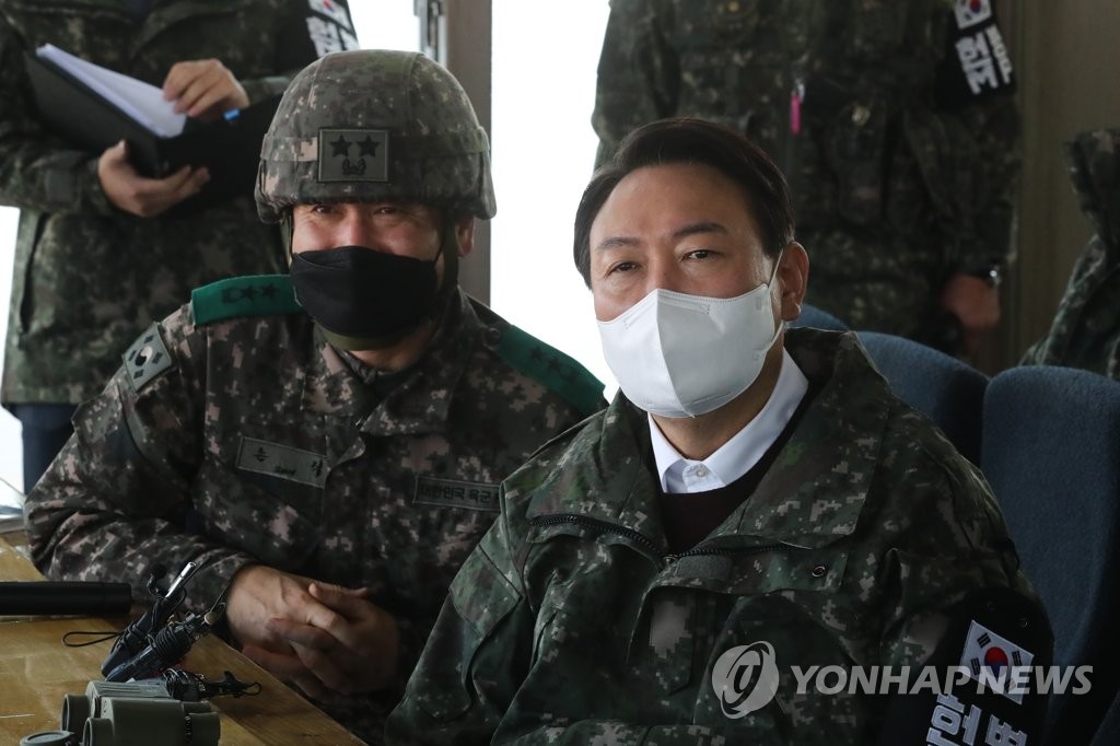 Yoon Suk-yeol (R), the presidential candidate of the main opposition People Power Party, watches a promotional video during his visit to the 3rd Infantry Division in Cheorwon, 88 kilometers north of Seoul, on Dec. 20, 2021. (Pool photo) (Yonhap)