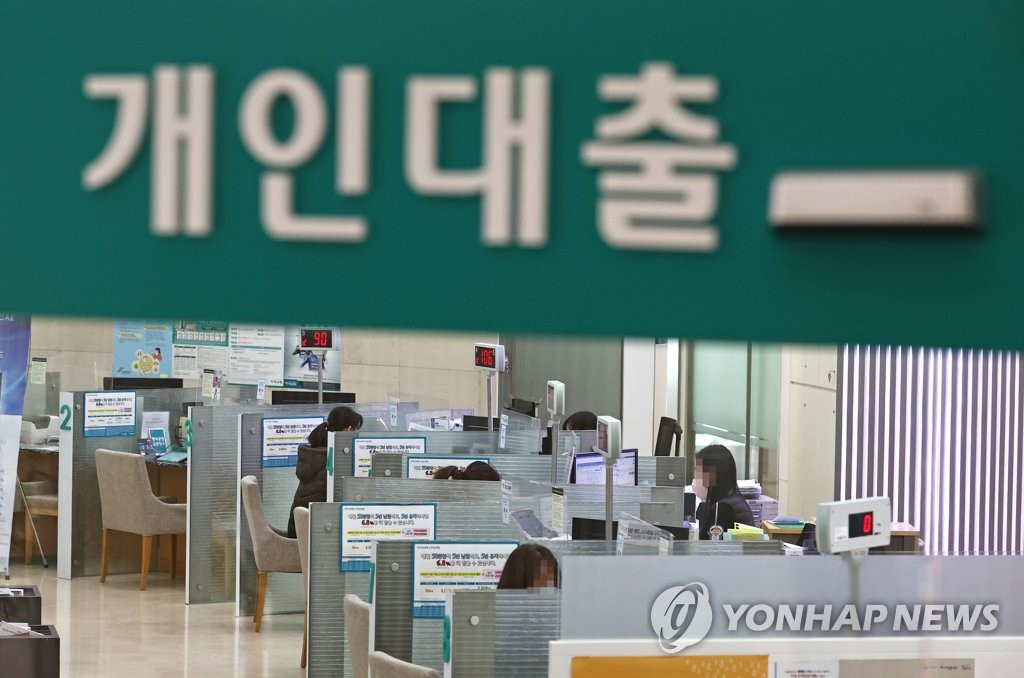 This file photo, taken Dec. 31, 2021, shows bank officials responding to customers' inquiries at a lender in Seoul. (Yonhap)