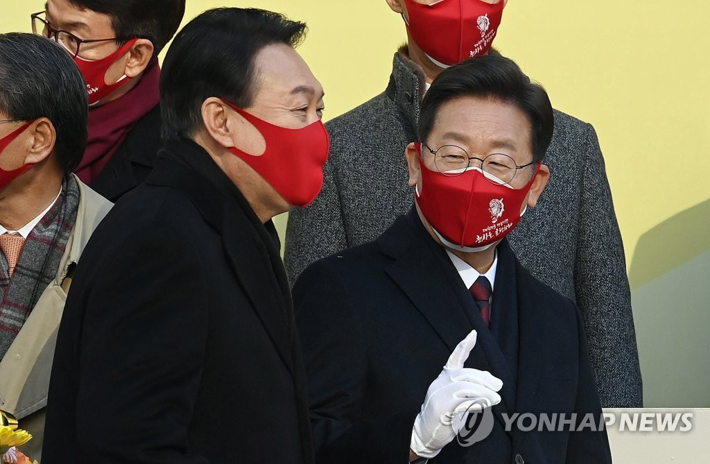 This photo taken on Jan. 3, 2022, shows Lee Jae-myung (R), the presidential candidate of the ruling Democratic Party (DP), and Yoon Suk-yeol, the presidential nominee of the main opposition People Power Party (PPP), at an event marking the new year opening of the Korea Exchange in Seoul. (Pool photo) (Yonhap)