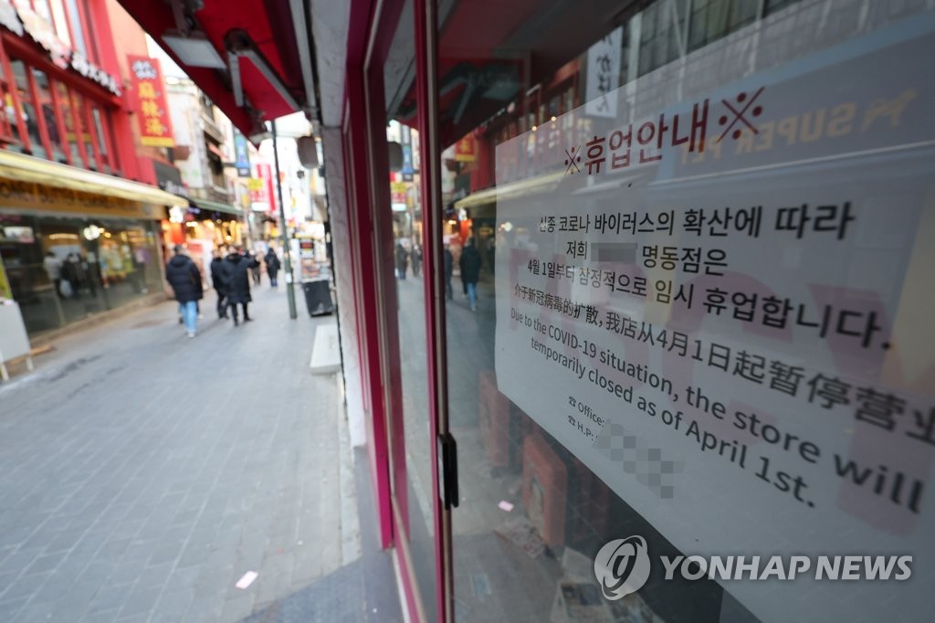 Cette photo, prise le 11 janvier 2022, montre une notice installée dans un magasin du quartier commerçant de Myeongdong, à Séoul, indiquant qu'il va fermer temporairement ses portes en raison de la pandémie de Covid-19. (Yonhap)