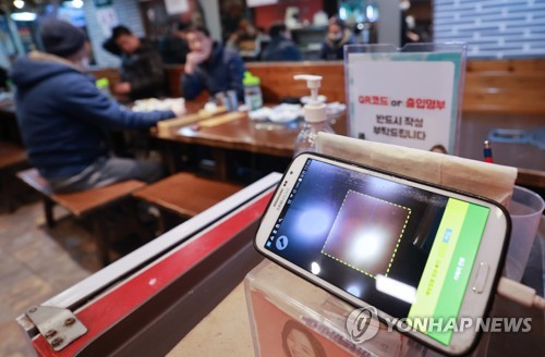 A mobile phone is installed at a restaurant in central Seoul on Jan. 13, 2022, to check vaccine passes. (Yonhap)