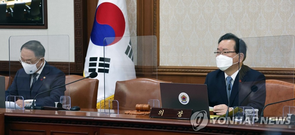 Le Premier ministre Kim Boo-kyum (à dr.) prend la parole lors d'une réunion extraordinaire du cabinet au complexe gouvernemental de Séoul, le 21 janvier 2022, pour approuver un plan budgétaire supplémentaire visant à aider les petits commerces touchés par la pandémie. A côté de lui se trouve le ministre de l'Economie et des Finances Hong Nam-ki.