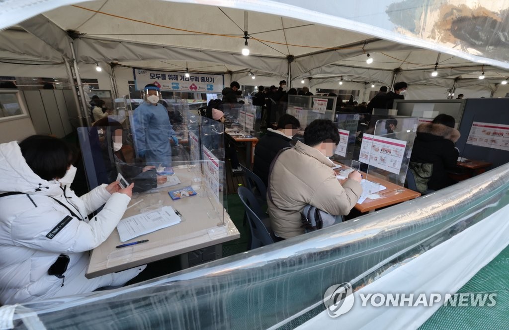 Citizens receive rapid antigen tests at a test center in eastern Seoul on Feb. 9, 2022. (Yonhap)