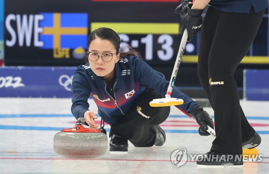 La capitaine sud-coréenne Kim Eun-jung lance une pierre lors d'un match de curling féminin du tournoi toutes rondes des Jeux olympiques d'hiver de Pékin 2022, au Centre aquatique national de Pékin, le jeudi 17 février 2022.
