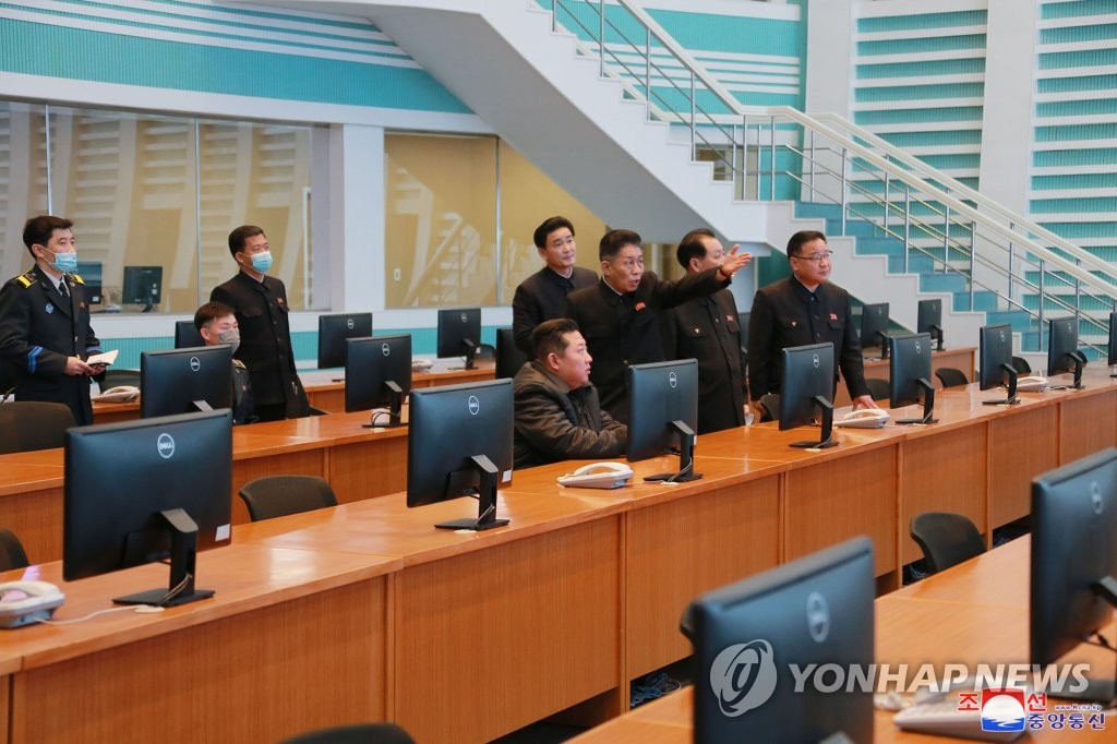 Le dirigeant nord-coréen Kim Jong-un converse avec des officiels durant sa visite à l'Administration nationale du développement aérospatial (NADA), a rapporté le jeudi 10 mars 2022 l'Agence centrale de presse nord-coréenne (KCNA). (Utilisation en Corée du Sud uniquement et redistribution interdite)