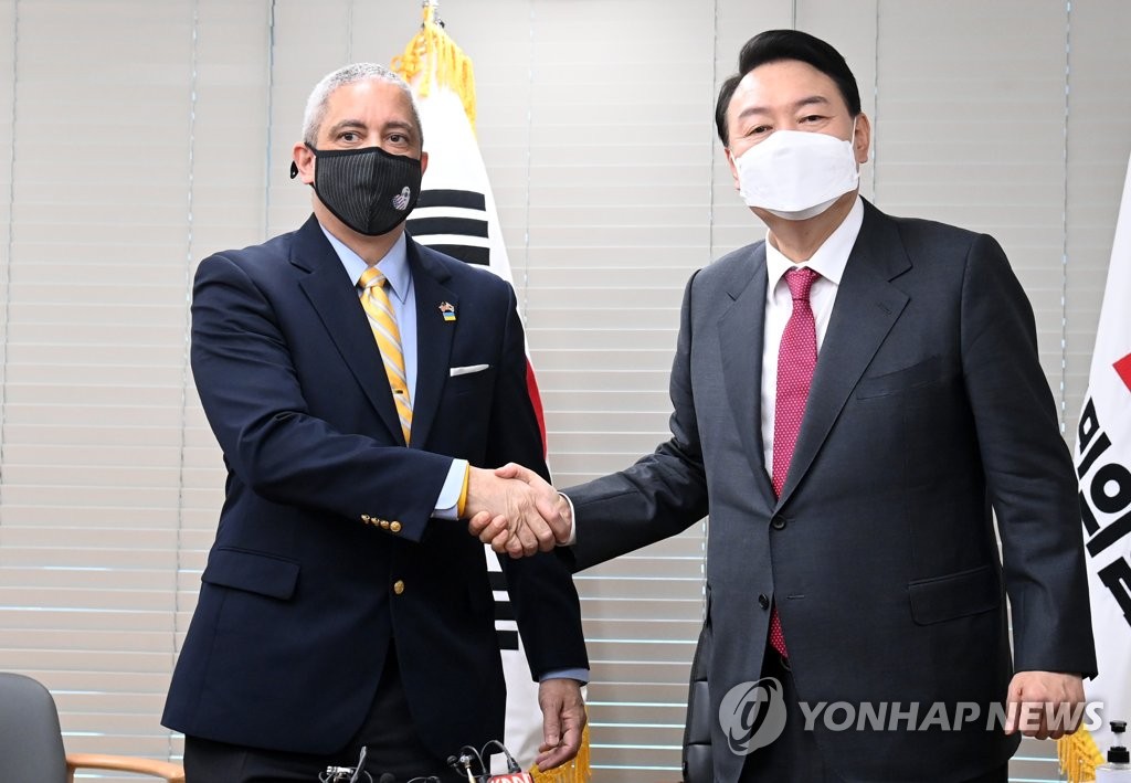 South Korean President-elect Yoon Suk-yeol (R) poses with U.S. Charge d'Affaires Christopher Del Corso during the latter's call on him at the main opposition People Power Party's headquarters in Seoul on March 11, 2022. (Pool photo) (Yonhap)