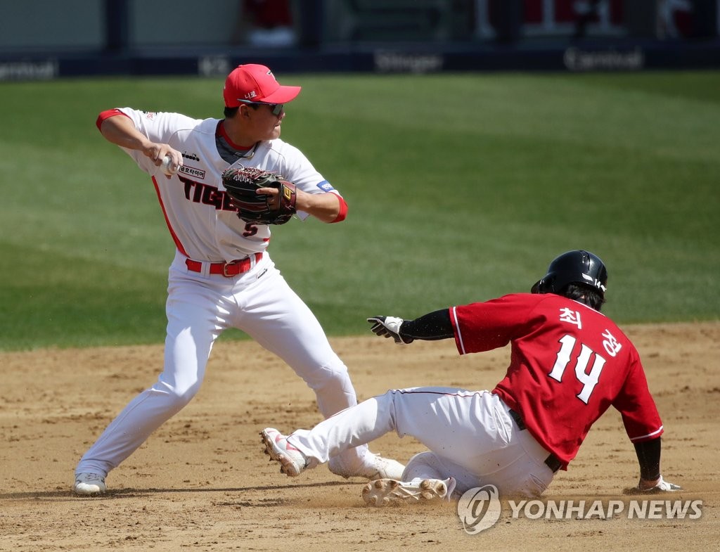 Kia Tigers shortstop Kim Do-young (L) makes a throw to first after Choi Jeong of the SSG Landers is forced out at second base during the top of the third inning of a Korea Baseball Organization preseason game at Gwangju-Kia Champions Field in Gwangju, some 330 kilometers south of Seoul, on March 29, 2022. (Yonhap)