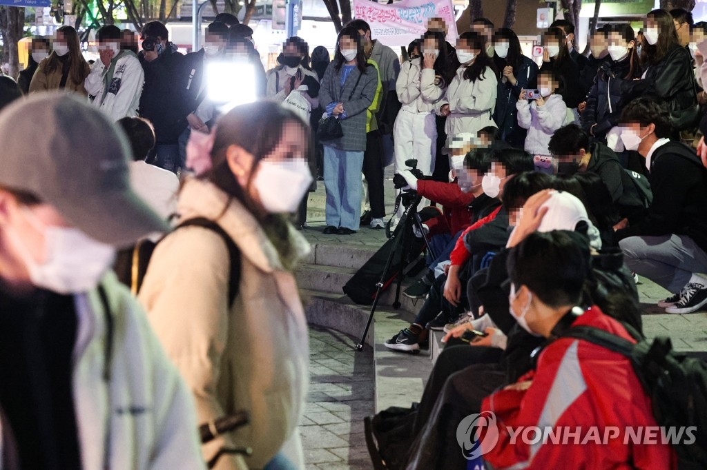 People watch a street performance in the popular hangout district of Hongdae in western Seoul on April 14, 2022. (Yonhap) 