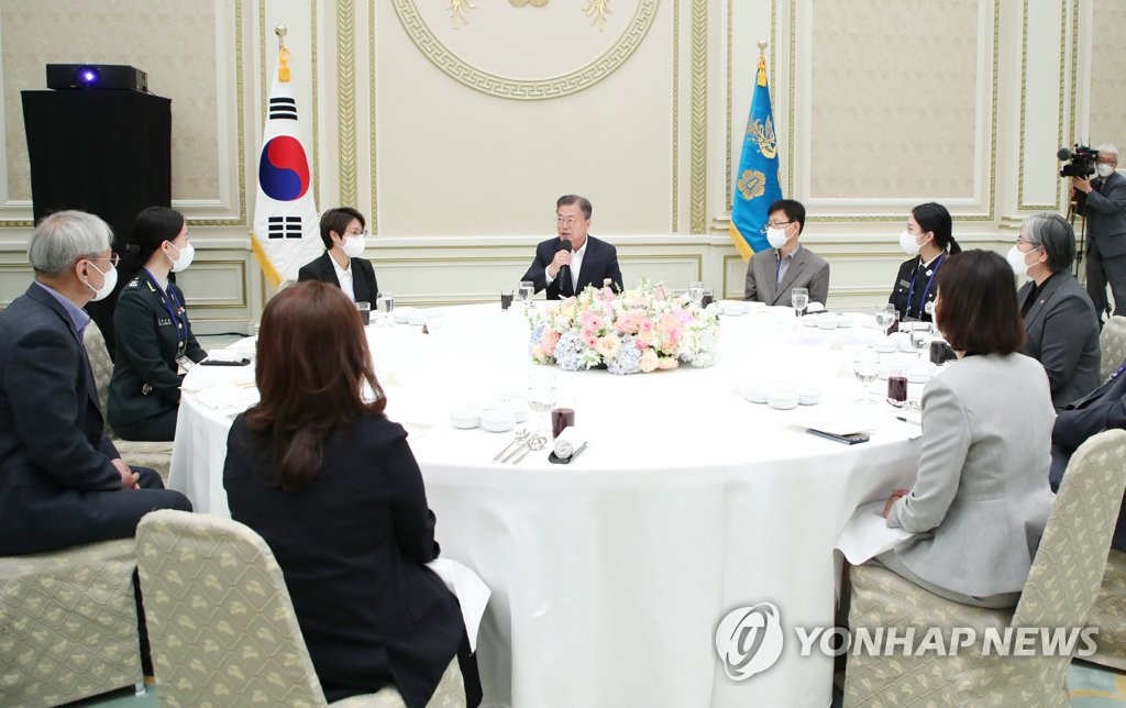 President Moon Jae-in (C, rear) speaks at the presidential office Cheong Wa Dae in Seoul on April 28, 2022, during his meeting with a group of people involved in quarantine operations against COVID-19. (Yonhap)