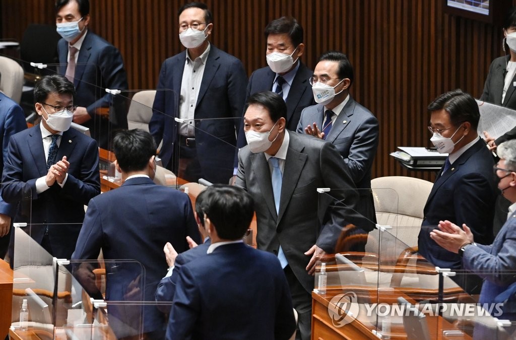 President Yoon Suk-yeol (C) meets lawmakers of the main opposition Democratic Party before he delivers a policy speech during a plenary session at the National Assembly in Seoul on May 16, 2022, about a government-proposed extra budget of 59.4 trillion won (US$46.3 billion) to help small merchants hit by the coronavirus pandemic. (Pool photo) (Yonhap)