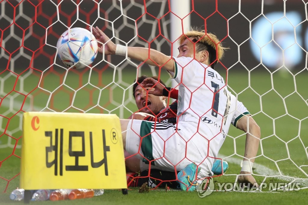 Takahiro Kunimoto of Jeonbuk Hyundai Motors (in white) ends up inside the net after scoring a goal against Pohang Steelers during the clubs' K League 1 match at Pohang Steel Yard in Pohang, 370 kilometers southeast of Seoul, on May 18, 2022. (Yonhap)