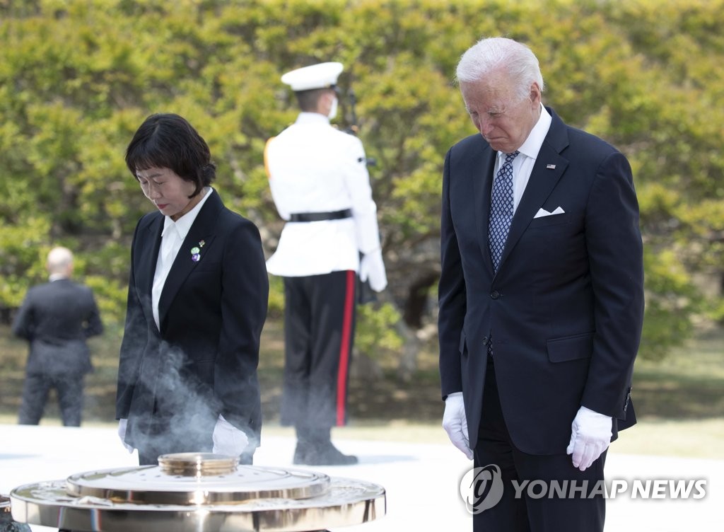 U.S. President Joe Biden (R) pays a silent tribute at the National Cemetery in Seoul on May 21, 2022. He visited the cemetery before holding a summit with President Yoon Suk-yeol at the presidential office. (Pool photo) (Yonhap)