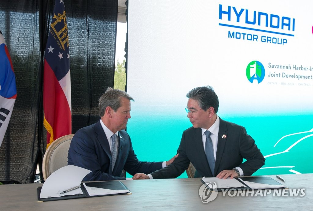 Georgia Gov. Brian Kemp (L) and Hyundai Motor Group President Jay Chang shake hands after signing an investment agreement on May 21, 2022, at the site where Hyundai will build an electric vehicle and car battery manufacturing plant in the U.S. state, in this photo released by the company (PHOTO NOT FOR SALE) (Yonhap)