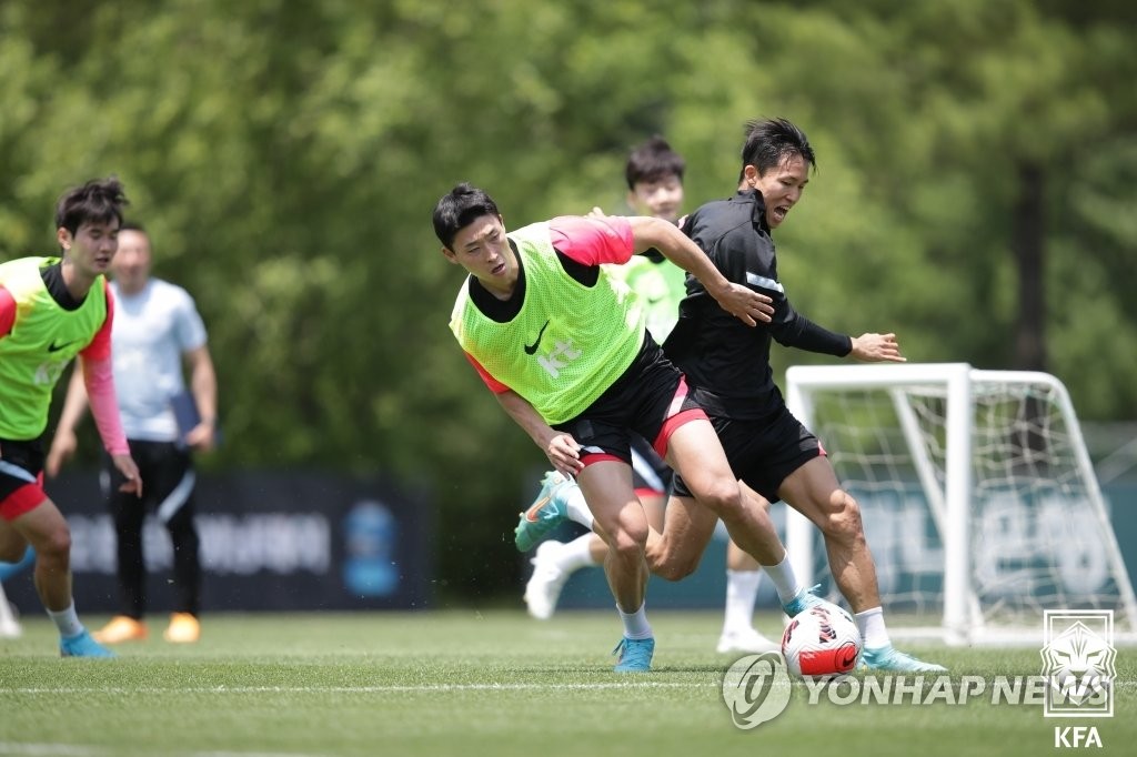 Cho Gue-sung (L) and Jeong Woo-yeong of South Korea battle for the ball during an opening training session for the men's national football team at the National Football Center in Paju, Gyeonggi Province, on June 11, 2022, in this photo provided by the Korea Football Association. (PHOTO NOT FOR SALE) (Yonhap)