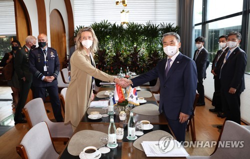 El ministro de Defensa de Corea del Sur, Lee Jong-sup (dcha.), y su homóloga neerlandesa, Kajsa Ollongren, estrechan sus manos, el 12 de junio de 2022, en Singapur, antes de sus conversaciones al margen del Diálogo de Shangri La, que se celebra de forma anual.