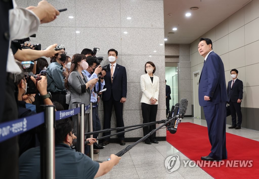 President Yoon Suk-yeol takes reporters' questions as he arrives at the presidential office in Seoul on June 20, 2022. (Yonhap)