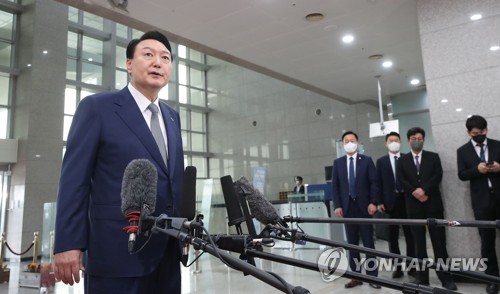 President Yoon Suk-yeol answers reporters' questions while arriving for work at his office in Seoul on June 24, 2022. (Pool photo) (Yonhap)